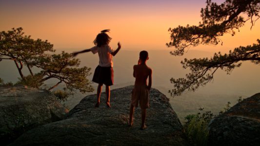 wannasa-wintawong-as-ja-and-tanapol-kamkunkam-as-boy-on-the-clifftop-at-sunset-in-the-forest